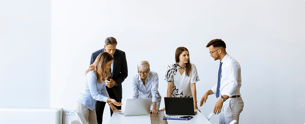 Team arbeitet gemeinsam an Laptops – Everyday AI: A Beginner’s Guide.