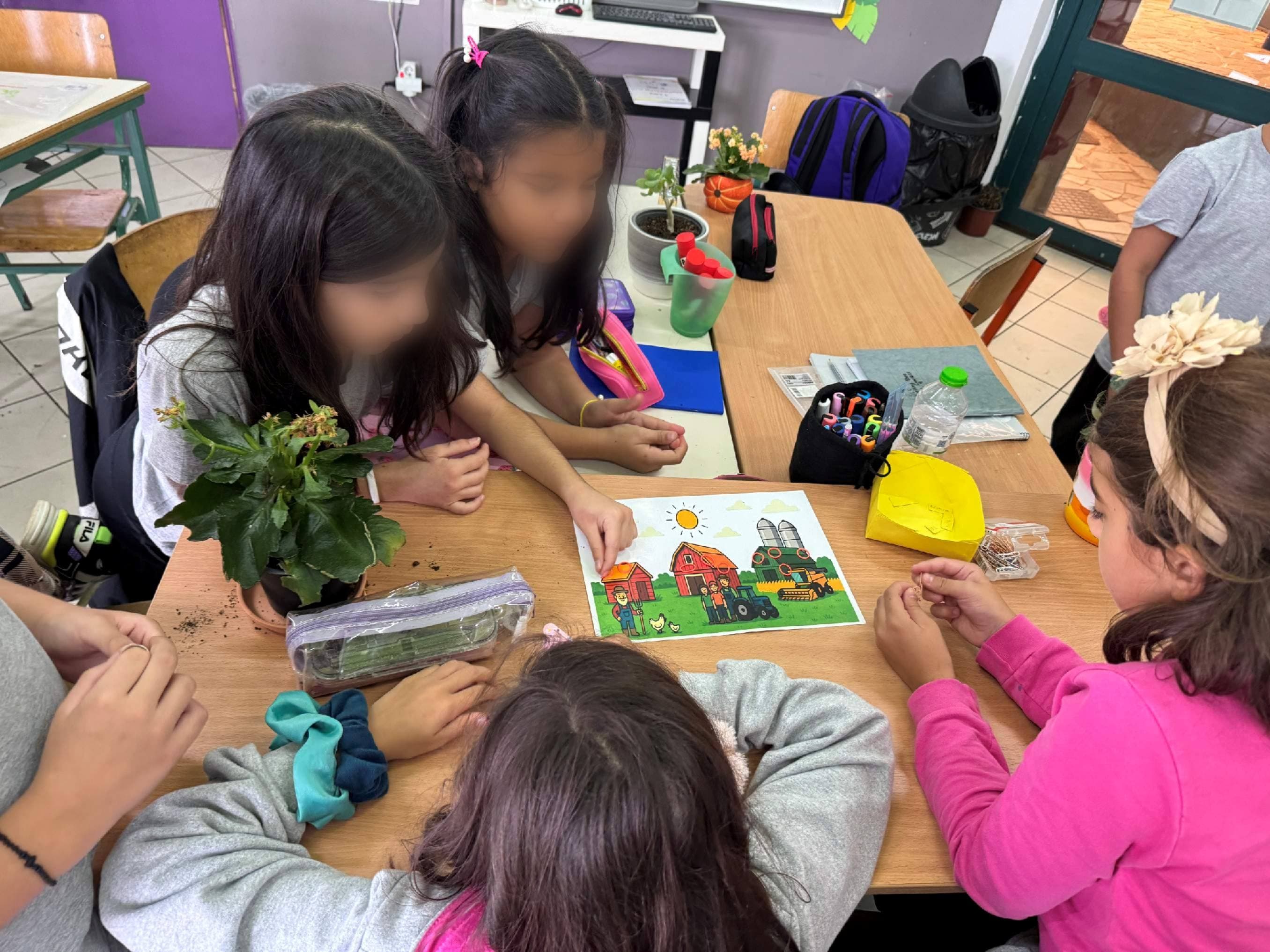 Kinder arbeiten gemeinsam an einem Tisch an einer Lernaufgabe.