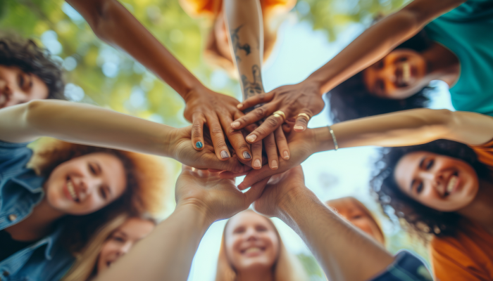 Eine Gruppe von Menschen, die sich im Kreis an den Händen halten