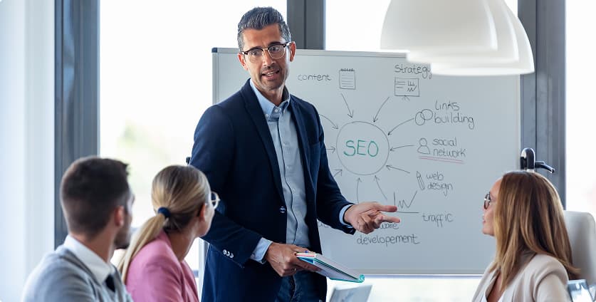 Fachmann präsentiert SEO‑Strategien für KI‑getriebene Websites mit Fokus auf Content, Links und Webdesign in einem modernen Büro.